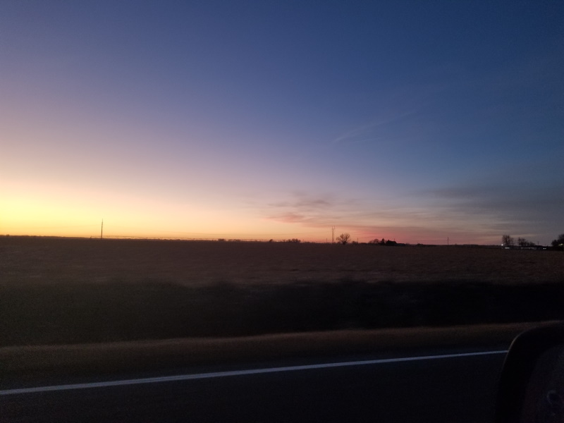 Photo of a Nebraska sunset out a car window.